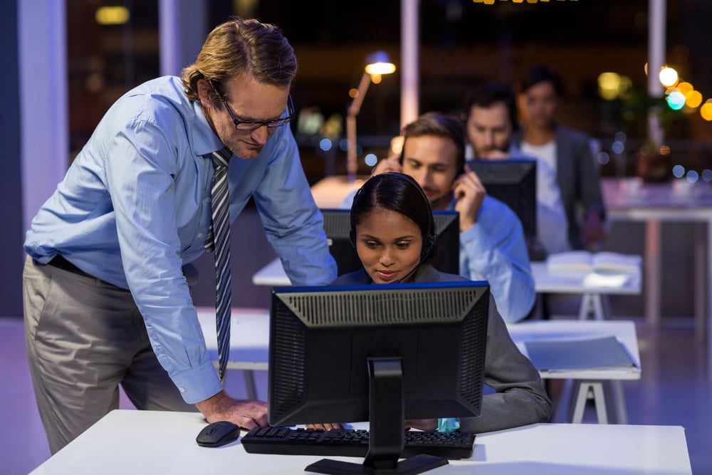 Businessman assisting his colleague in office at night