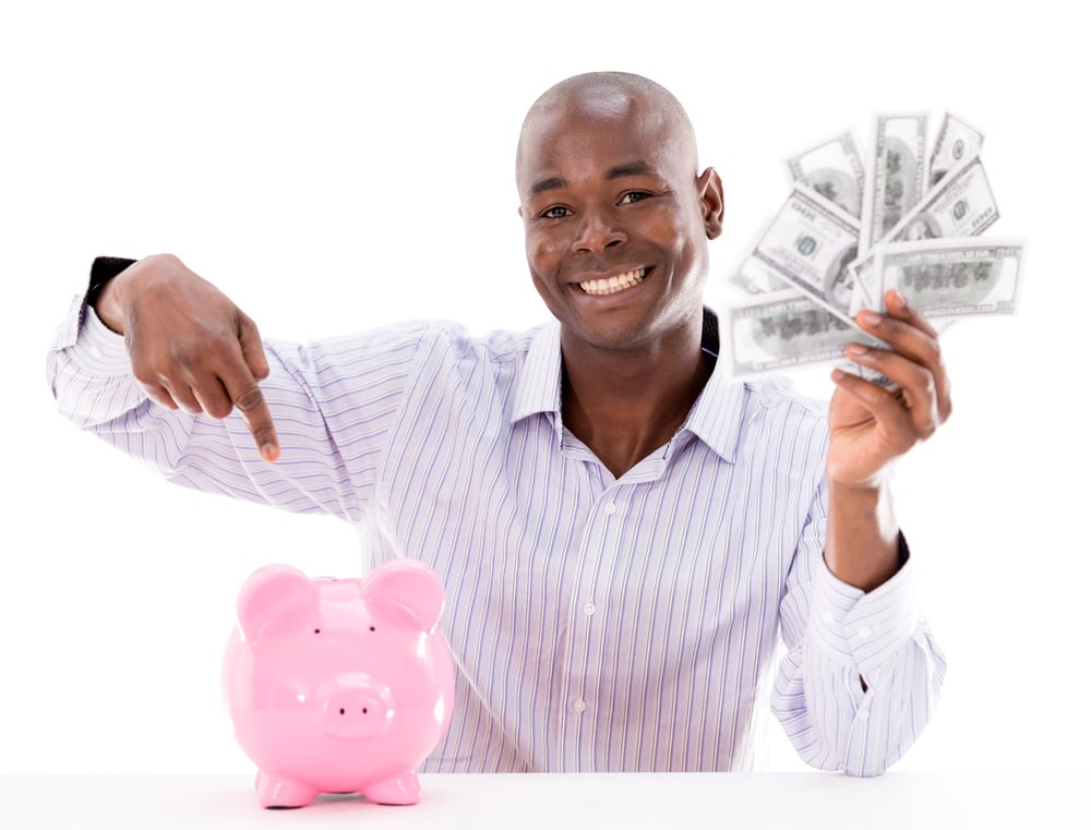Happy man saving money in a piggybank - isolated over white